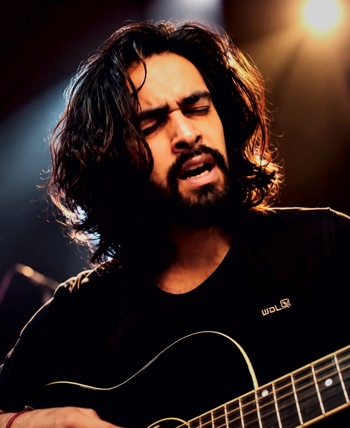 Singer playing guitar during a performance